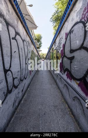 Ein langer Flur führt zu einem unterirdischen Durchgang mit Graffiti an den Wänden Stockfoto