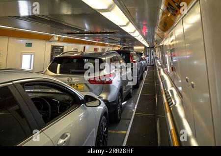 Personenkraftwagen, die mit dem Eurotunnel-Zug Le Shuttle über den Kanaltunnel von Folkestone im Vereinigten Königreich nach Calais in Frankreich geladen werden. Stockfoto