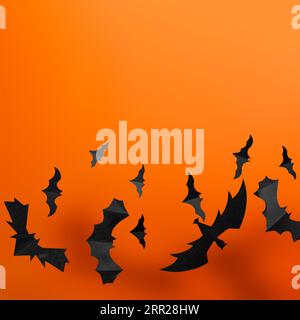 Halloween-Papierdekorationen schwarze Papierschläger fliegen auf orangem Hintergrund Stockfoto