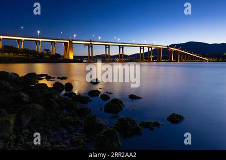 Die berühmte Tasman Bridge in der Abenddämmerung an einem klaren Frühlingsabend über den Derwent River im Zentrum von Hobart, Tasmanien, Australien. Schuss aus der Clarence Stockfoto