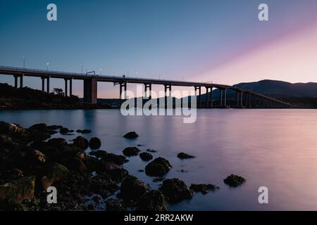 Die berühmte Tasman Bridge in der Abenddämmerung an einem klaren Frühlingsabend über den Derwent River im Zentrum von Hobart, Tasmanien, Australien. Schuss aus der Clarence Stockfoto