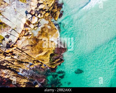 Die berühmten Flechten bedeckten Felsen und das türkisfarbene Ozeanwasser in der Bay of Fires, aufgenommen als Luftbild in der Nähe von Binalong Bay, Tasmanien, Australien Stockfoto