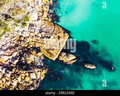 Die berühmten Flechten bedeckten Felsen und das türkisfarbene Ozeanwasser in der Bay of Fires, aufgenommen als Luftbild in der Nähe von Binalong Bay, Tasmanien, Australien Stockfoto