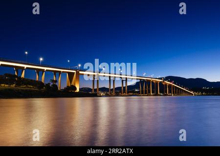 Die berühmte Tasman Bridge in der Abenddämmerung an einem klaren Frühlingsabend über den Derwent River im Zentrum von Hobart, Tasmanien, Australien. Schuss aus der Clarence Stockfoto