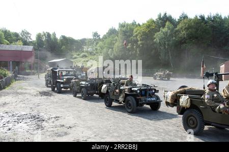 Konvoi von Militärfahrzeugen auf einer staubigen Straße. Stockfoto