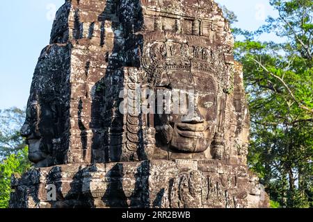 Riesige Steingesichter des alten Bayon-Tempels. Die Steinwände des khmer-Königs an der Mauer des Bayon-Tempels, Angkor Thom, Siem Reap, Kambodscha. Stockfoto