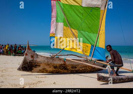 Auslegerboot am Strand mit farbenfrohem Segel, Westküste, Madagaskar Stockfoto