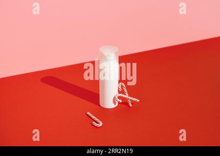 Flasche kosmetische Creme mit Zuckerrohr auf rosafarbenem Hintergrund Stockfoto