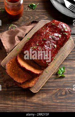 Hackbraten mit Glasur auf Schneidebrett auf Holzhintergrund. Nahaufnahme Stockfoto