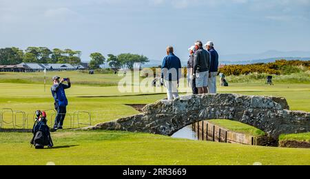 Golfer posieren für Fotos auf dem Golfplatz Swilcan Bridge, Old Course, St Andrews, Fife, Schottland, UK Stockfoto
