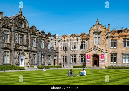 Universitätsstudenten entspannen auf Rasen, St Salvator's College Quadrangle, St Andrews University, Fife, Schottland, Großbritannien Stockfoto