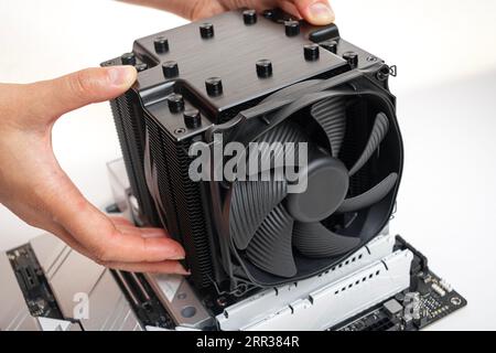 Installieren eines großen Kühlers auf einem Computerprozessor. Stockfoto