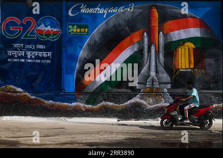 New Delhi, Delhi, Indien. September 2023. Ein Mann auf seinem Fahrrad bewegt sich vor dem G20-Gipfel in Neu-Delhi, Indien, am 6. September 2023 an einer Wand vorbei, die eine Müllhalde umgibt, neben einem Logo des G20-Gipfels. Indien wird ab September 9-10 den 18. G20-Gipfel in Neu-Delhi ausrichten. (Bild: © Kabir Jhangiani/ZUMA Press Wire) NUR REDAKTIONELLE VERWENDUNG! Nicht für kommerzielle ZWECKE! Stockfoto