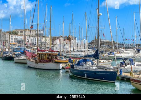 Mittags am Ramsgate Yachthafen. Mit Fischerbooten, Yachten, kleinen Booten und Schnellbooten. Hellblauer Himmel und Reflexionen auf dem Meer. Stockfoto