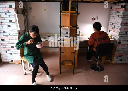 201029 -- HEFEI, 29. Oktober 2020 -- Cheng Dongdong und seine Mutter Liu Xiang essen im Studentenwohnheim der Chaohu Universität in Chaohu, Ostchinesische Provinz Anhui, 19. Oktober 2020. Cheng Dongdong wurde 2001 in der Stadt Qiucun in Guangde geboren und 2008 mit Amyotropher Lateralsklerose als diagnostiziert. Von der Grundschule bis zur Highschool hatte Cheng Hilfe von seinen Klassenkameraden erhalten. Im September 2020 begann Cheng sein Universitätsleben und erhielt Unterstützung durch seine neuen Klassenkameraden wie zuvor. CHINA-ANHUI-UNIVERSITY STUDENT-ALS-UNTERSTÜTZUNG VON KLASSENKAMERADEN CN LIUXJUNXI PUBLICATIONXNOTXINXCHN Stockfoto