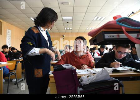 201029 -- HEFEI, 29. Oktober 2020 -- Cheng Dongdong spricht mit Lehrer an der Chaohu Universität in Chaohu, ostchinesische Provinz Anhui, 19. Oktober 2020. Cheng Dongdong wurde 2001 in der Stadt Qiucun in Guangde geboren und 2008 mit Amyotropher Lateralsklerose als diagnostiziert. Von der Grundschule bis zur Highschool hatte Cheng Hilfe von seinen Klassenkameraden erhalten. Im September 2020 begann Cheng sein Universitätsleben und erhielt Unterstützung durch seine neuen Klassenkameraden wie zuvor. CHINA-ANHUI-UNIVERSITY STUDENT-ALS-UNTERSTÜTZUNG VON KLASSENKAMERADEN CN ZHANGXDUAN PUBLICATIONXNOTXINXCHN Stockfoto