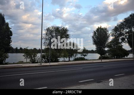 Lakeshore mit Bäumen bei Sonnenuntergang von einer Straße in einer italienischen Stadt aus gesehen Stockfoto