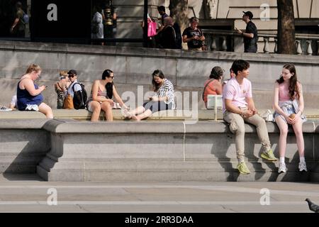 London, Großbritannien. September 2023. Touristen auf dem Trafalgar-Platz sitzen am Brunnen, während die Hitzewelle in der Hauptstadt weitergeht. Hohe Temperaturen werden voraussichtlich bis nächste Woche andauern. Danksagung: Elfte Stunde Fotografie/Alamy Live News Stockfoto