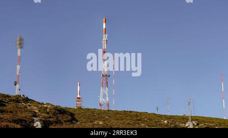 Rot-weißes altes Kommunikationszentrum von der Spitze eines Mahuntain gegen den tiefblauen Himmel Stockfoto