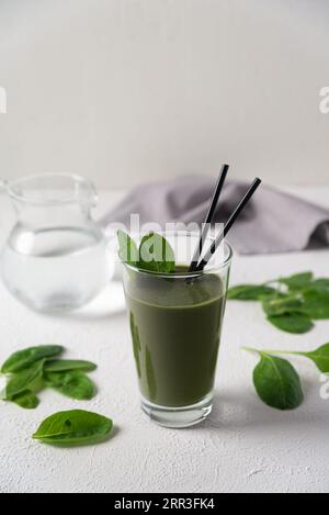 Gesunder grüner Smoothie mit Spinat im Glas auf weißem Hintergrund. Erfrischender Grüner Smoothie. Stockfoto
