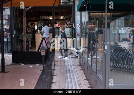 201103 -- ATHEN, 3. Nov. 2020 -- Eine Frau mit Maske geht am 3. Nov. 2020 durch ein Café, das nur zum Mitnehmen in Athen, Griechenland, angeboten wird. Angesichts der Zunahme der Fälle kündigte der griechische Premierminister Kyriakos Mitsotakis am 31. Oktober eine neue Reihe von Beschränkungen an, die am 3. November beginnen und bis Dezember andauern werden, um eine vollständige landesweite Lockdown wie die im Frühjahr verhängte zu vermeiden. In stark alarmierten Regionen mit hoher epidemiologischer Belastung, darunter Attika, schließen Restaurants und Cafeterien mit Ausnahme von Take-Away- und Zustelldiensten. GRIECHENLAND-ATHEN-RESTRI Stockfoto