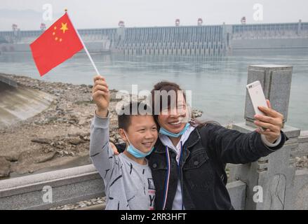 201103 -- YICHANG, 3. November 2020 -- Besucher nehmen ein Selfie in einem Park in der Nähe des Three Gorges Project in der Stadt Yichang, Zentralchinas Provinz Hubei, 1. November 2020. Das Three Gorges-Projekt, das den Wasserfluss auf dem chinesischen Yangtze-Fluss steuert, wurde offiziell als vollständig und voll funktionsfähig zertifiziert, gaben die Behörden am Sonntag bekannt. Chinas Ministerium für Wasserressourcen und die nationale Entwicklungs- und Reformkommission kündigten den offiziellen vollständigen Abschluss des Projekts an, da es alle Konstruktionsanforderungen erfüllt, eine gute Gesamtleistung aufweist und die Schlüsselrolle erfüllt Stockfoto