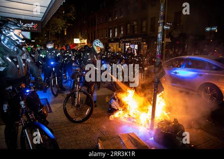 201105 -- NEW YORK, 5. November 2020 -- Ein Polizist zündet ein Feuer, das von Demonstranten während eines Protestes ausgelöst wird, bei dem gefordert wird, dass jede Stimme für die Präsidentschaftswahl in New York, den Vereinigten Staaten, am 4. November 2020 gezählt werden sollte. Demonstrationen fanden in Städten wie Washington, D.C., Los Angeles, Raleigh und Portland statt, wobei Emotionen aufbrannten und Dutzende von Verhaftungen gemeldet wurden. Foto von /Xinhua US-NEW YORK-PRÄSIDENTSCHAFTSWAHLPROTEST MichaelxNagle PUBLICATIONxNOTxINxCHN Stockfoto