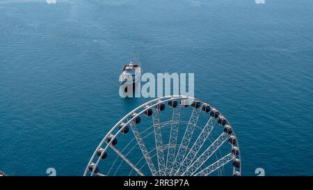 Seattle, WA, USA. September 2023. Ein Fährboot bringt seine Passagiere mit einem Riesenrad im Vordergrund ans Ufer. (Bild: © Walter G Arce SR Grindstone Medi/ASP) NUR REDAKTIONELLE VERWENDUNG! Nicht für kommerzielle ZWECKE! Stockfoto