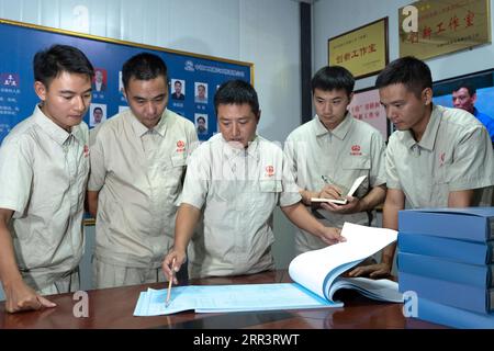 201110 -- VIENTIANE, 10. November 2020 -- Xu Zhou C macht einen Punkt, als er mit seinen Kollegen über technische Probleme im Büro des China-Laos-Eisenbahnprojekts am nördlichen Stadtrand von Vientiane, Hauptstadt von Laos, am 5. August 2020 spricht. Die China-Laos-Eisenbahn ist ein strategisches Andockprojekt zwischen der von China vorgeschlagenen Belt and Road Initiative und der Laos-Strategie, um das Binnenland in ein landverbundenes Drehkreuz umzuwandeln. Der chinesische Ingenieur Xu Zhou, der mit der 4. Mai-Medaille ausgezeichnet wurde, eine nationale Top-Auszeichnung für junge Chinesen, führt seine Gruppe von der China Railway No. 2 Engineering Group CREC-2 nach Stockfoto