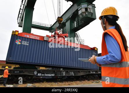 201113 -- XIAMEN, 13. November 2020 -- Ein Mitarbeiter schaut zu, wie ein Container auf einen China-Europa-Güterzug nach Hamburg in der Station Haicang in Xiamen, südöstliche Provinz Fujian, am 13. November 2020 geladen wird. In den ersten drei Quartalen 2020 wurden auf der Station Haicang of China Railway Nanchang Group Co., Ltd. Insgesamt 204 chinesisch-europäische Güterzüge verzeichnet, was einem Anstieg von 160 Personen gegenüber dem gleichen Zeitraum im Jahr 2019 entspricht. Der Frachtwert über die Zugverbindungen erreichte etwa 700 Millionen US-Dollar. CHINA-FUJIAN-CHINA-EUROPE GÜTERZUG CN WEIXPEIQUAN PUBLICATIONXNOTXINXCHN Stockfoto