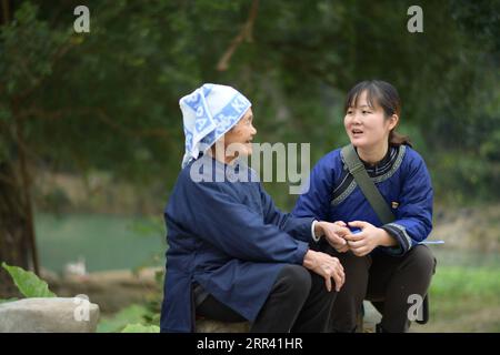 201117 -- QIANDONGNAN, 17. November 2020 -- Liu YuanR, ein hochrangiger Armutshilfeoffizier, spricht mit einem älteren Dorfbewohner im Dorf Balu im Kreis Rongjiang, Qiandongnan Miao und der autonomen Präfektur Dong, Provinz Guizhou im Südwesten Chinas, 16. November 2020. Liu Yuan, 32, arbeitet seit November 2019 als Beamter für Armutsbekämpfung auf primärer Ebene im Dorf Balu im Kreis Rongjiang. In ihrer täglichen Arbeit bemühte sie sich, praktische Probleme für die Dorfbewohner zu lösen, einschließlich der Empfehlung von Arbeitsplätzen für die Arbeitslosen, der Hilfe für umgesiedelte Haushalte, die ihre Shanty-Häuser abrissen, und der Pflege von mir Stockfoto