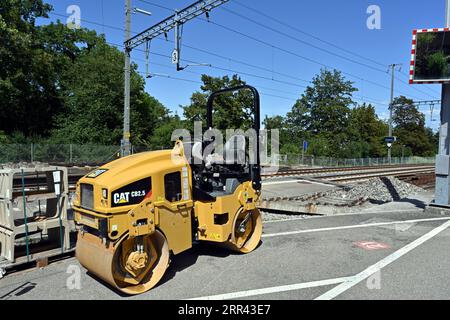 Kleine gelbe Tandem-Vibrationswalzen von Caterpillar Company, die beim Wiederaufbau des Bahnhofs in Urdorf, Schweiz, verwendet werden. Stockfoto