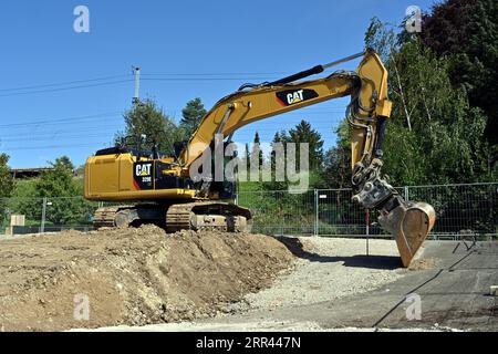 Raupenbagger mit Schaufellader, der auf der Baustelle eines Einfamilienhauses arbeitet. Stockfoto