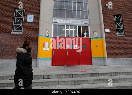 201119 -- NEW YORK, 19. November 2020 -- Eine Frau geht am 19. November 2020 am Eingang einer öffentlichen Schule in New York, USA vorbei. Der Bürgermeister von New York, Bill de Blasio, gab am Mittwoch bekannt, dass alle öffentlichen Schulen in der Stadt ab Donnerstag geschlossen werden würden, da die COVID-19-Infektionsrate im 7-Tage-Durchschnitt 3 Prozent übersteigt. U.S.-NEW YORK-COVID-19-PUBLIC SCHOOLS-CLOSURE WANGXYING PUBLICATIONXNOTXINXCHN Stockfoto