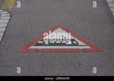 Verkehrsschild für Straßenbahnüberquerung vor Ihnen auf dem Boden gemalt. Stockfoto