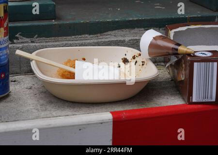 Einweggabel in einem Styroporbehälter für Straßennahrung mit gebrauchten Servietten und einigen Essensresten. Stockfoto