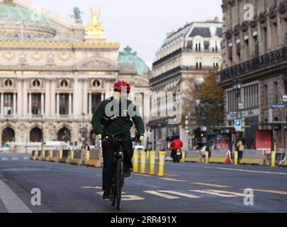 201125 -- PARIS, 25. November 2020 -- Ein Mann mit einer Gesichtsmaske fährt Ein Fahrrad in Paris, Frankreich, 25. November 2020. Die Franzosen werden ab Samstag mehr Freiheit bei Outdoor-Übungen genießen, und die landesweite Coronavirus-Abriegelung könnte am 15. Dezember aufgehoben werden, wenn die gesundheitlichen Bedingungen erfüllt sind, kündigte Präsident Emmanuel Macron am Dienstag in einer TV-Ansprache an. FRANCE-PARIS-COVID-19-LOCKDOWN-EASING GaoxJing PUBLICATIONxNOTxINxCHN Stockfoto
