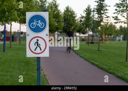 Straßenschild, das Fußgänger, Radfahrer verbietet. Das Fahrbahnsymbol zeigt die Fahrradroute auf der Fußgängerbrücke an. Stockfoto