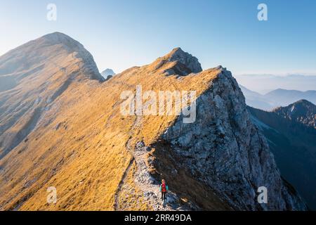 Bergsteigen auf dem Berg, eine junge Frau, die auf dem Weg mit Trekkingstöcken auf dem Bergkamm wandert Stockfoto