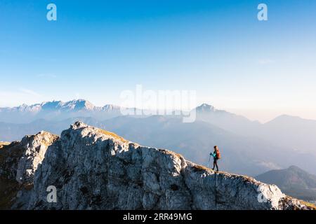 Bergsteigen auf dem Berg, eine junge Frau, die auf dem Weg mit Trekkingstöcken auf dem Bergkamm wandert Stockfoto
