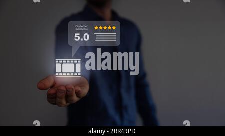 Junger gutaussehender Kerl, der sich glücklich fühlt und mit guter Geste Zustimmung zeigt. Filmkonzept. Stockfoto