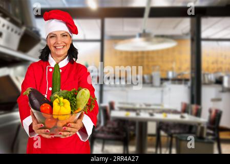 Fröhliche Frau in Geschäftskleidung, eine Blume haltend, selbstbewusst lächelnd in die Kamera. Stockfoto
