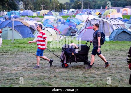 Personen, die am ersten Tag mit einem Trolley ankommen. Green man Festival, Brecon, Wales, Großbritannien, 2023. Foto: Rob Watkins Stockfoto