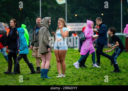 Zwei Teenagermädchen im Regen und Schlamm. Green man Festival, Brecon, Wales, Großbritannien, 2023. Foto: Rob Watkins Stockfoto