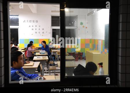 201202 -- WUHU, 2. Dezember 2020 -- Xi Weijing, Leiterin der Schule für Blinde in Wuhu, fragt eine Schülerin nach ihrem Lebens- und Studienzustand an der Schule in Wuhu, ostchinesische Provinz Anhui, 25. November 2020. XI Weijings Eltern sind beide sehbehindert. Ihr Vater Xi Manqiao gründete 1979 eine private Schule für Blinde und widmete all seine Energie der Arbeit der Schule. Nachdem ihr Vater 1994 an Krankheit gestorben war, übernahm Xi Weijing, damals in ihren 20ern, die Last und wurde der zweite Direktor der Wuhu Schule für Blinde. Mit Unterstützung der örtlichen Regierung hat die Wuhu Schule für Blinde Stockfoto