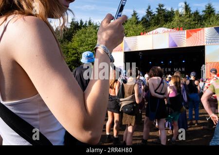 Eine junge Frau schaut ihr Handy auf der Walled Garden Stage beim Green man Festival, Brecon, Wales, Großbritannien, 2023. Foto: Rob Watkins Stockfoto