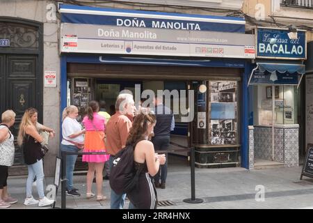 Eine lange Schlange vor dem Büro der Lotto-Agentur Dona Manolita, die darauf wartet, Tickets für die spanische Weihnachtslotterie, El Gordo, Madrid Spanien, zu kaufen. Stockfoto