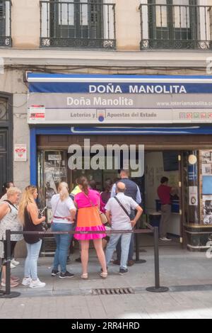 Eine lange Schlange vor dem Büro der Lotto-Agentur Dona Manolita, die darauf wartet, Tickets für die spanische Weihnachtslotterie, El Gordo, Madrid Spanien, zu kaufen. Stockfoto