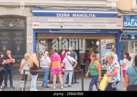 Eine lange Schlange vor dem Büro der Lotto-Agentur Dona Manolita, die darauf wartet, Tickets für die spanische Weihnachtslotterie, El Gordo, Madrid Spanien, zu kaufen. Stockfoto