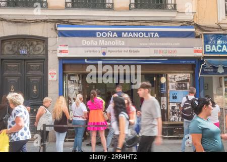 Eine lange Schlange vor dem Büro der Lotto-Agentur Dona Manolita, die darauf wartet, Tickets für die spanische Weihnachtslotterie, El Gordo, Madrid Spanien, zu kaufen. Stockfoto